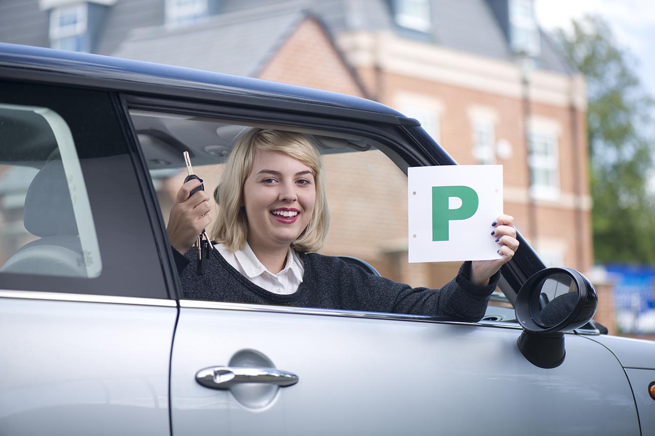 Girl holding p plates after passing her test